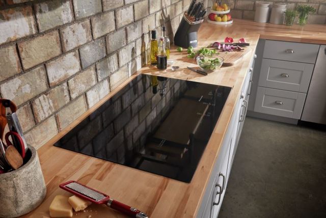 Front view of a 30" electric cooktop from KitchenAid built into a butcher block countertop.