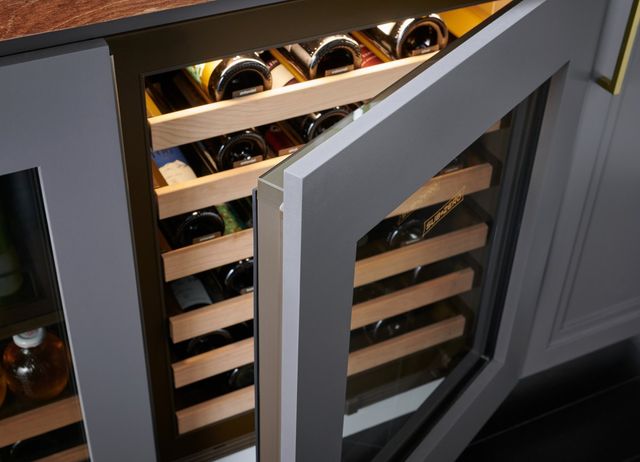 Close front view of a slightly opened and fully stocked under the counter wine refrigerator