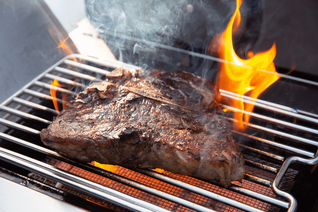Credit: Napoleon Close view of a steak being seared on a Napoleon grill