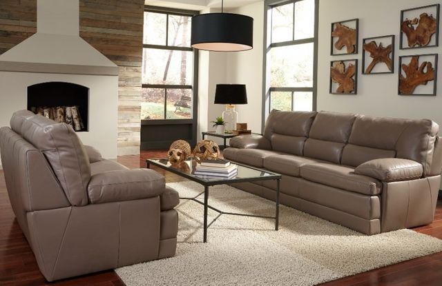 front view of a rustic living room with a brown leather sofa and loveseat