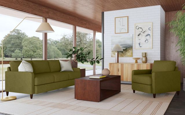 front view of a green Flexsteel sofa in a modern living room with large windows and brown wooden accents