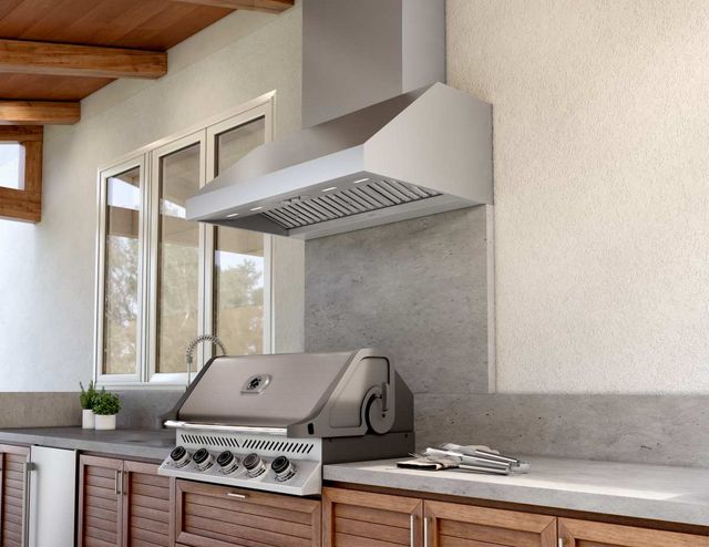 Close view of a grill with a range hood in a modern outdoor space