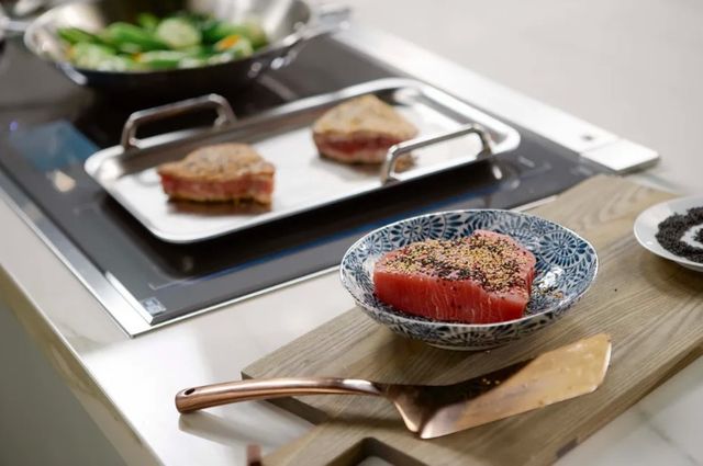 View of salmon cooking on an induction cooktop
