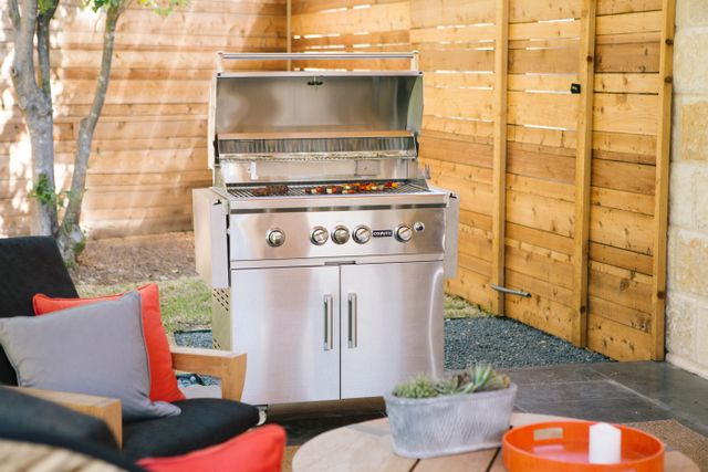 Front view of a freestanding Coyote gas grill and smoker combo