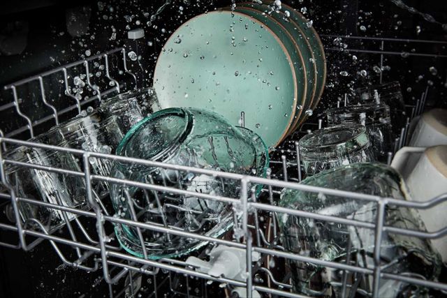 front view of the inside of an energy star certified dishwasher with water washing dishes