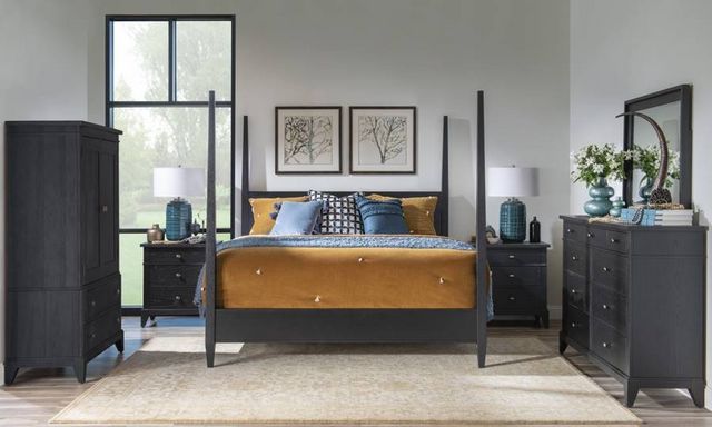 front view of a modern bedroom with a black four poster bed and matching side tables and dresser