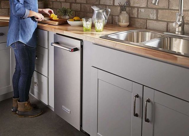View of a woman cutting lemons for drinks on the counter above her built in ice maker