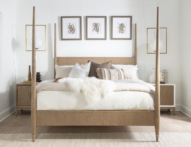 front view of a white boho bedroom with light wooden furniture including a four poster bed 