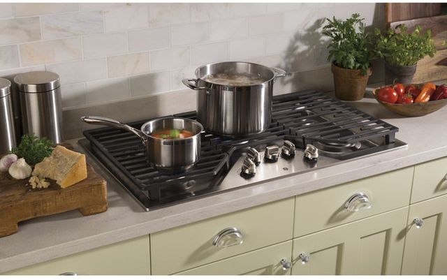 View of a gas cooktop with two pots of food cooking on top