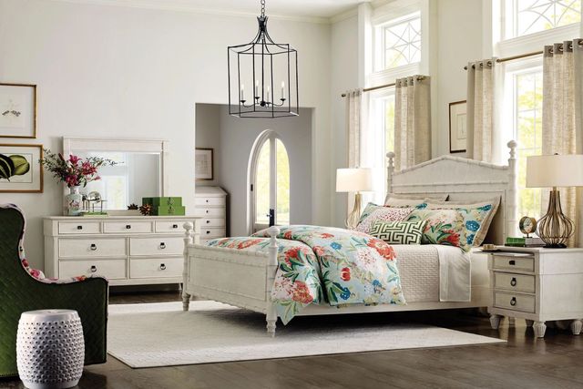 View of a costal style bedroom with light furniture and a bamboo style poster bed