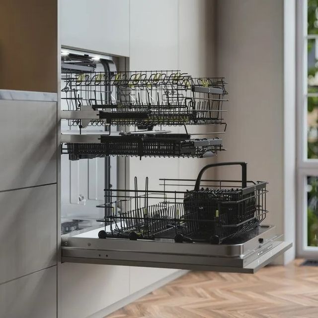 Side view of a built in opened dishwasher with all three drawers pulled out