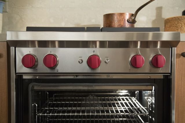 Close view of a Wolf 30” gas range opened with a pot on top Close view of a Wolf 30” gas range opened with a pot on top
