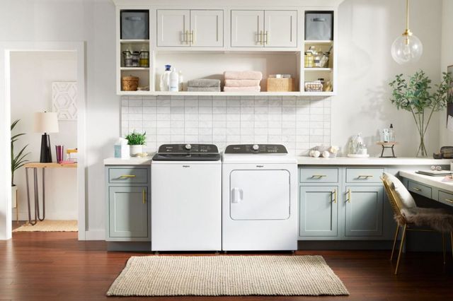 front view of a modern laundry room with a white top load washer and dryer