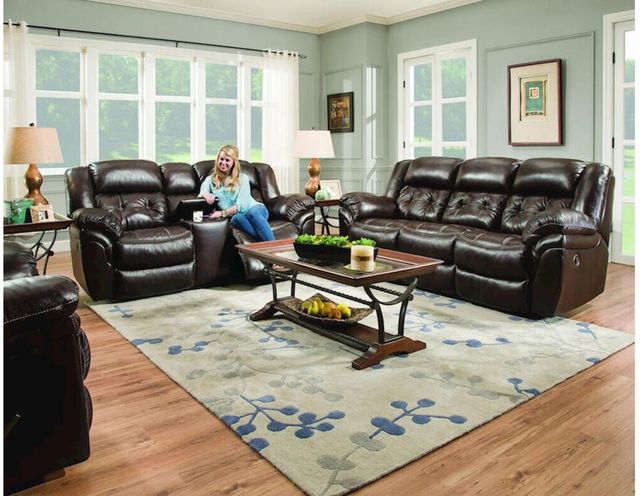 front view of a woman sitting and smiling on a leather loveseat with a matching sofa