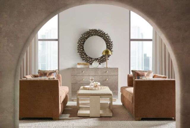 Front view of a modern living room with a dresser cabinet along the wall, two couches on either side, viewing through an archway