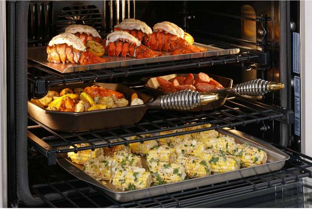 view of inside of a Monogram wall oven with lobster and corn cooking inside