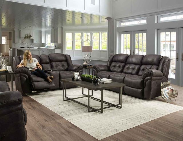 front view of a woman sitting on a grey sofa in a modern living room