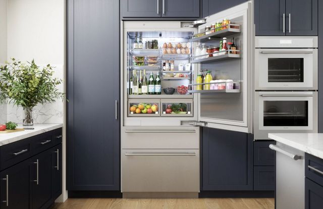 Front view of a Thermador bottom freezer refrigerator with the top fridge open