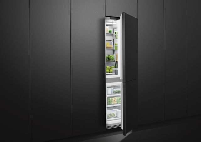 View of a wall of black cabinetry and an opened Fisher & Paykel bottom freezer refrigerator
