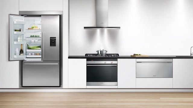 Front view of a modern kitchen with white cabinets and stainless steel Fisher & Paykel appliances