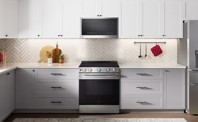 Front view of a modern kitchen with a range and over the range microwave from LG
