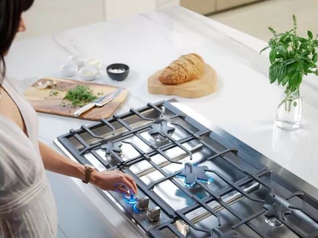 view of a woman cooking on a thermador gas range
