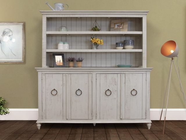front view of a whitewashed wooden dining hutch with four lower cabinets and three upper shelves with various decor on them