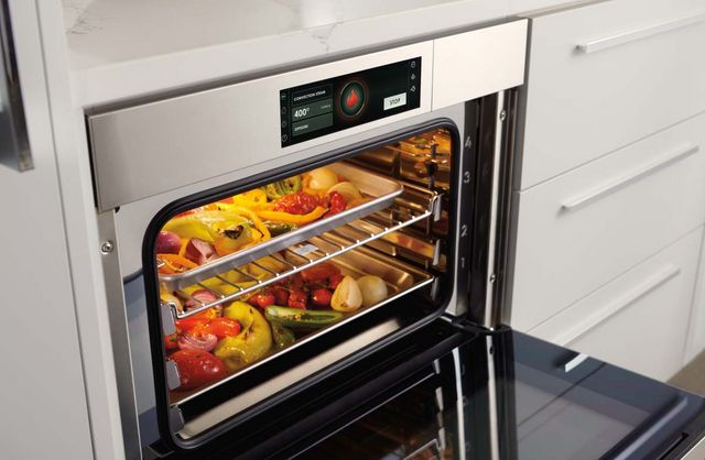 Close view of an opened Steam oven with veggies inside.