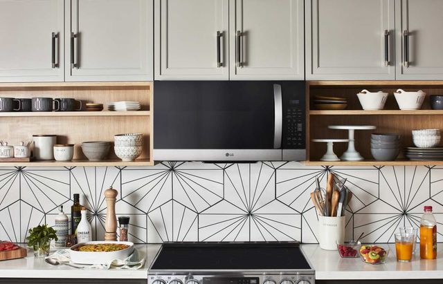 Front view of a modern kitchen with a flat top range and over the range microwave