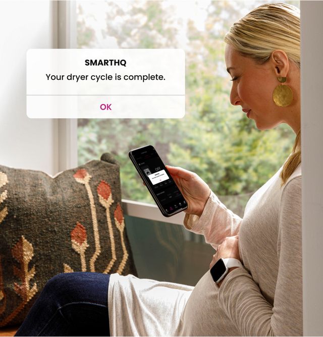 View of a woman getting a notification on her phone from the SmartHQ app