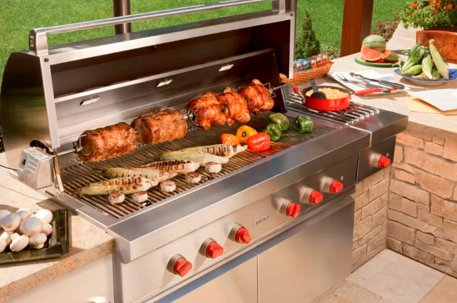 Front view of an opened Wolf grill with various food and veggies being grilled on top?