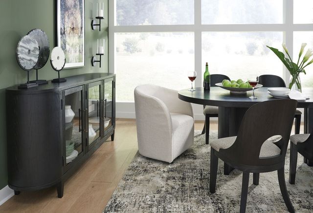 side view of a mid-century modern dining room with sage green walls, a black round dining table with white seats around it, and a matching round mid-century modern sideboard on the left