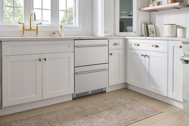 front view of stainless steel refrigerator drawers in a modern white kitchen