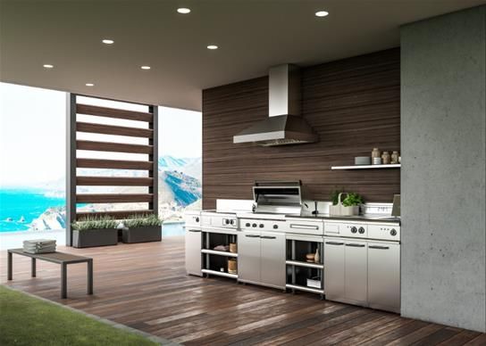 View of a luxury outdoor kitchen with a grill, range hood, and cabinetry