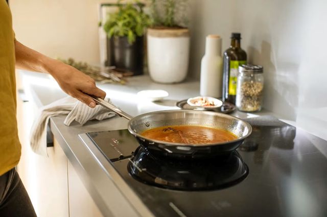 Credit: Electrolux Close view of someone cooking on an induction cooktop