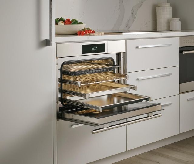 Front view of an opened Wolf speed oven with the racks pulled out.
