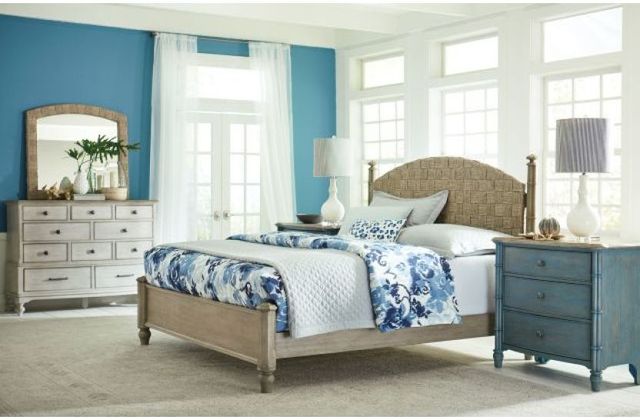 Front view of a modern coastal bedroom with light wooden furniture and a panel bed with blue walls