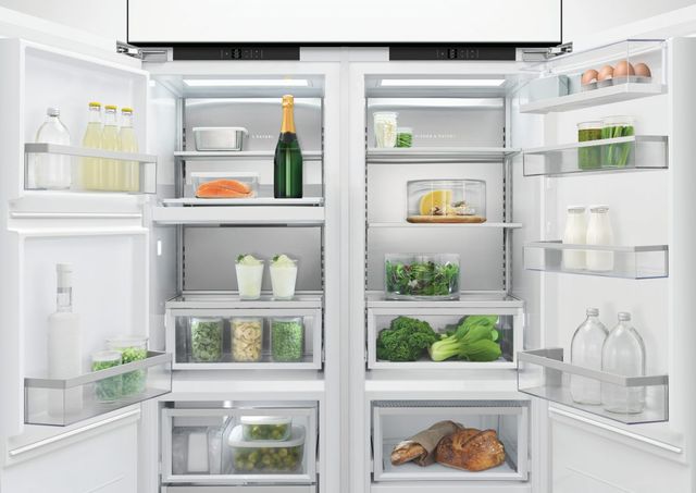 Front view of an opened Fisher & Paykel refrigerator stocked with various food and drinks