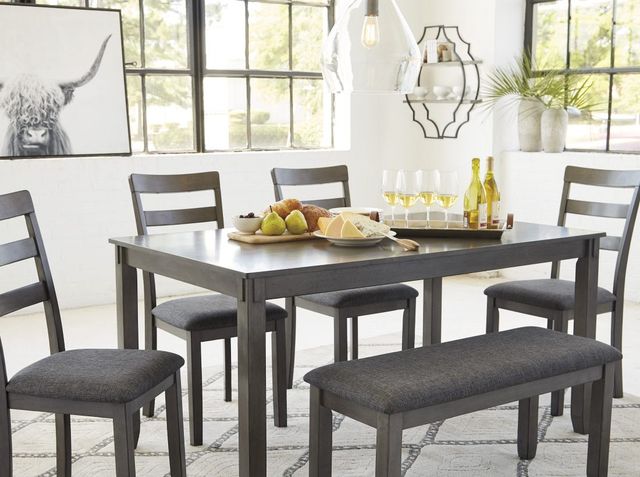 view of a grey dining table with bench and chairs in a modern rustic dining room