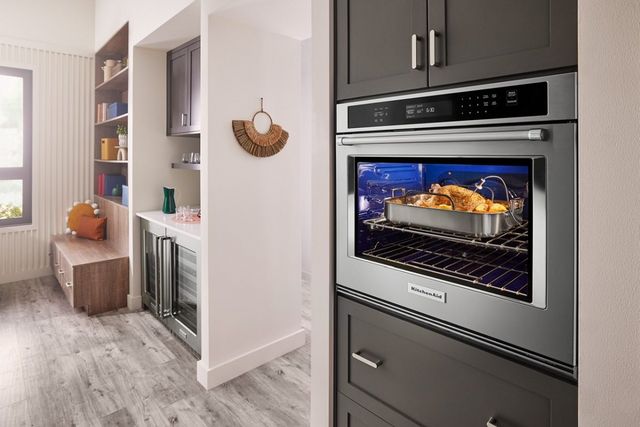 Front view of a KitchenAid convection oven with a turkey cooking inside