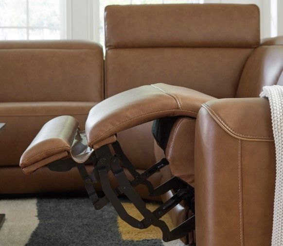 Close view of a brown leather recliner with the recliner slightly reclined