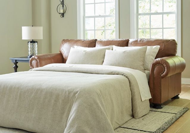 Front view of a modern brown leather sofa bed pulled out in a modern living room 
