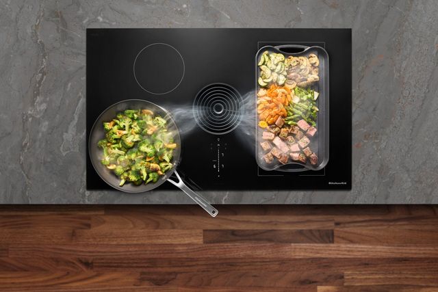 Credit: KitchenAid Top view of a KitchenAid downdraft cooktop with foods cooking on top