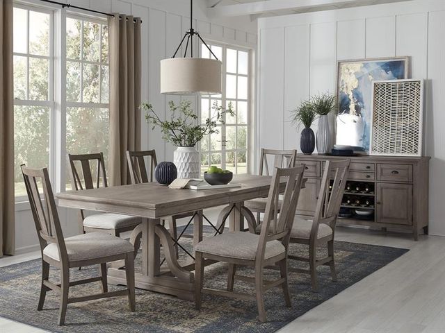 front view of a casual dining room with a grey wooden table and matching sideboard
