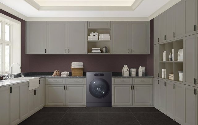 Woman loading a front load washer dryer combo appliance