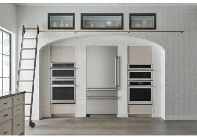 Front view in a modern kitchen with a built in Monogram bottom freezer refrigerator and a double wall ovens on both sides