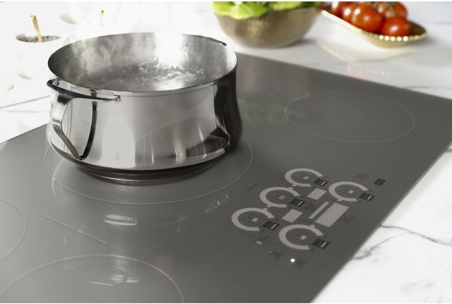 Close view of a Monogram induction cooktop with a pot of water boiling on top