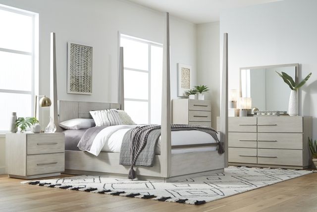 View of a modern white bedroom with modern white furniture including a white four poster bed and matching dressers