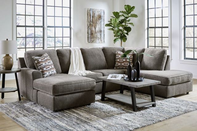Front view of a modern living room with a Signature Design by Ashley U-shaped sectional