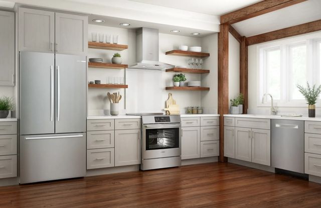 front view of a modern kitchen with white cabinets and stainless steel appliances including a french door refrigerator, a slide in convection range, a range hood, and a dishwasher